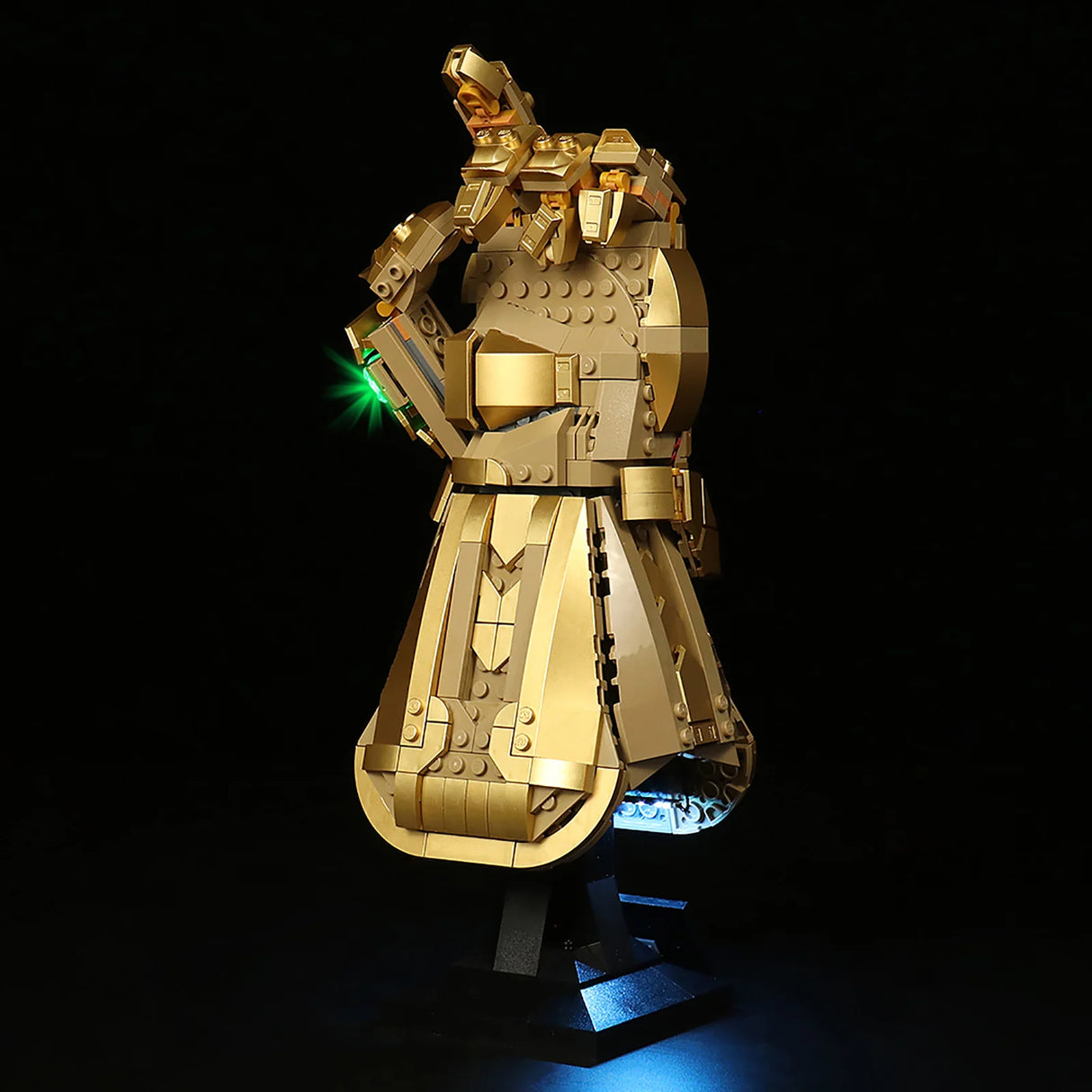 Goldener Infinity Handschuh aus Lego Steinen mit leuchtendem grünen Stein auf schwarzem Hintergrund