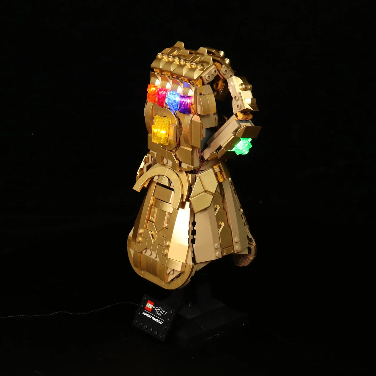 Lego Infinity Gauntlet Modell mit leuchtenden Infinity Steinen auf schwarzem Hintergrund