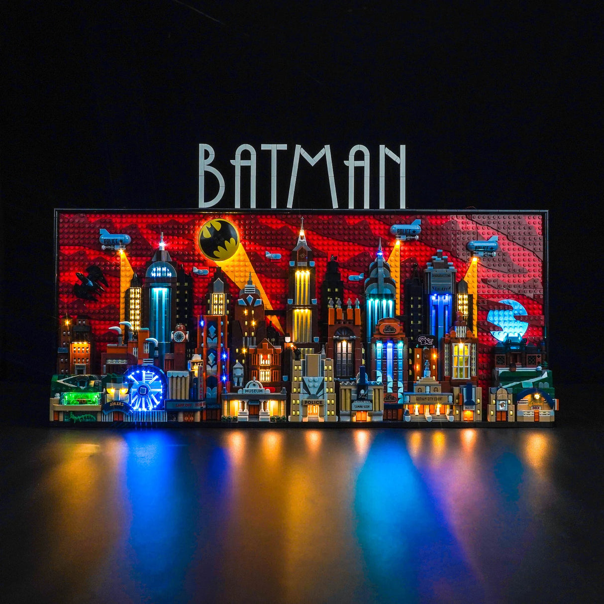 Beleuchtetes Lego Modell der Skyline von Gotham City mit Batman Logo vor rotem Hintergrund