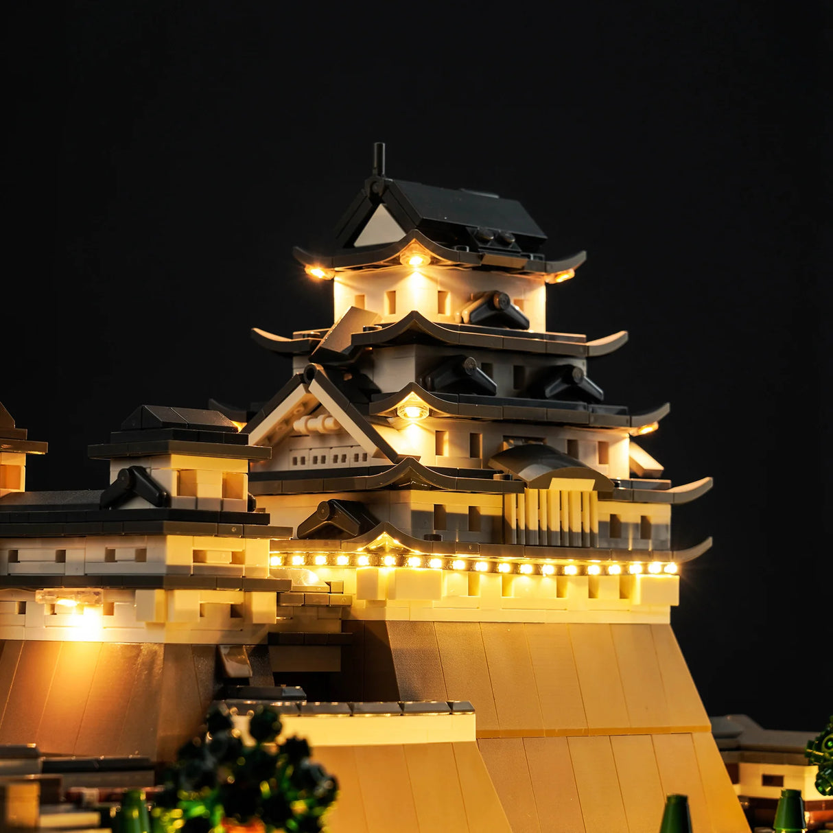 Beleuchtetes Modell einer japanischen Burg aus Klemmbausteinen vor schwarzem Hintergrund