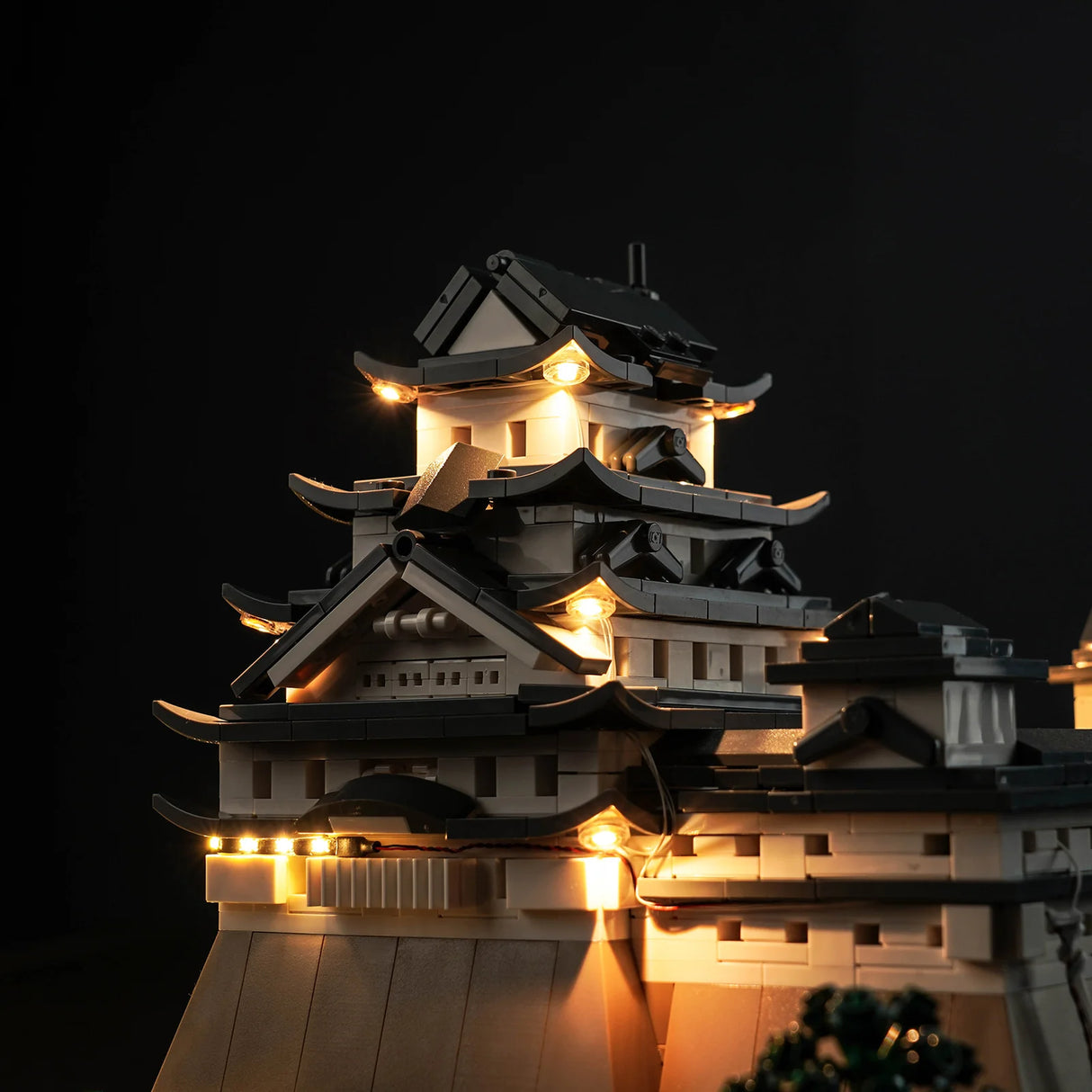 Beleuchtetes Modell einer japanischen Burg aus Klemmbausteinen vor schwarzem Hintergrund