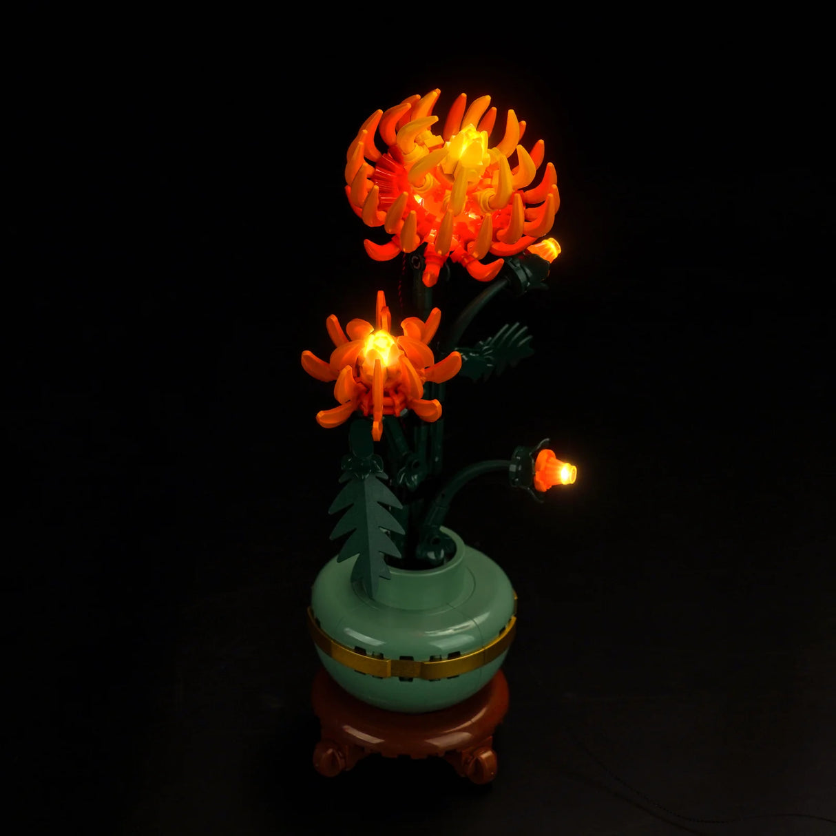 Beleuchtete Lego Chrysantheme in einer Vase vor schwarzem Hintergrund