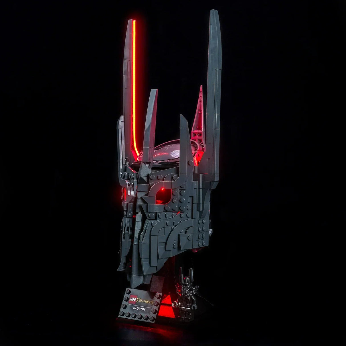 Saurons Helm aus LEGO mit roter Beleuchtung, auf einem Ständer mit Namensschild