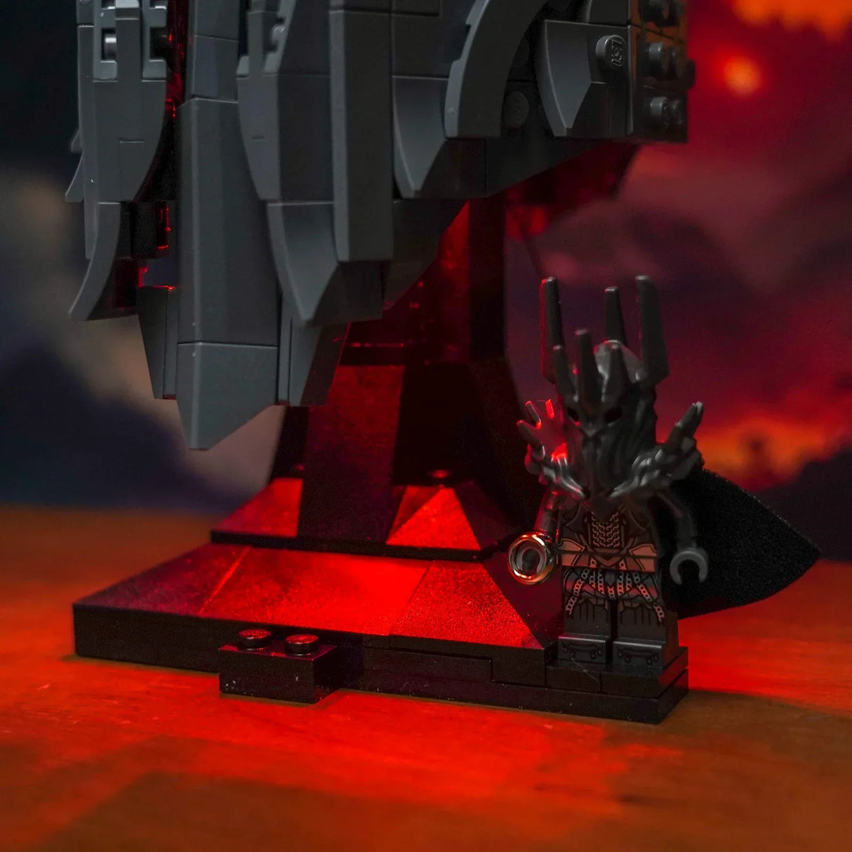 Lego Sauron Minifigur mit dem Einen Ring vor einem dunklen Turm mit roter Beleuchtung