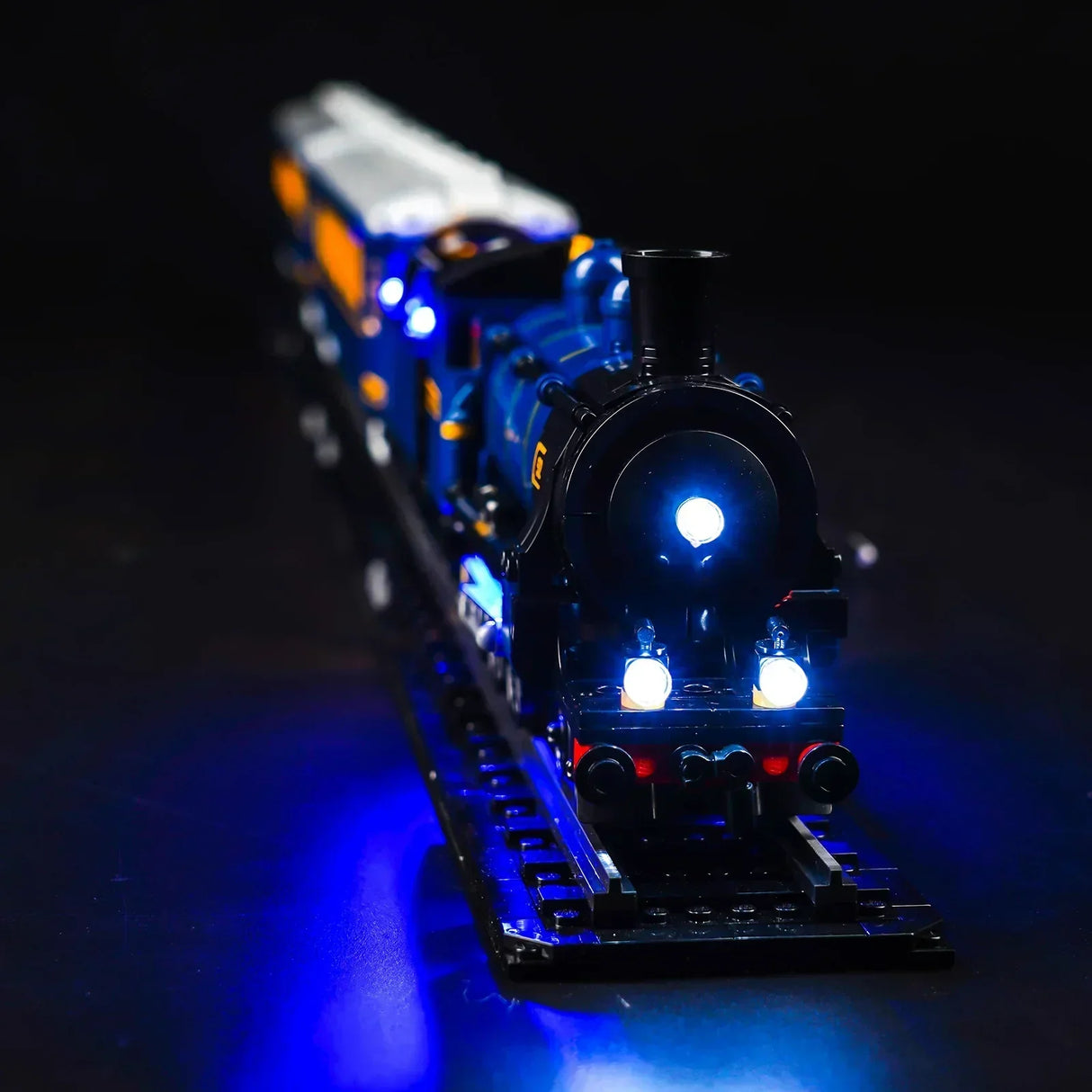 Modelleisenbahn aus Klemmbausteinen mit blauer LED Beleuchtung auf schwarzem Hintergrund