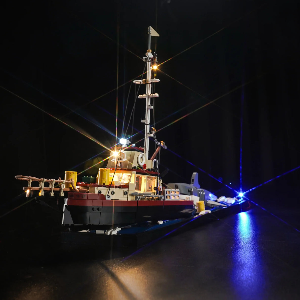 Beleuchtetes Modellschiff aus Klemmbausteinen vor schwarzem Hintergrund
