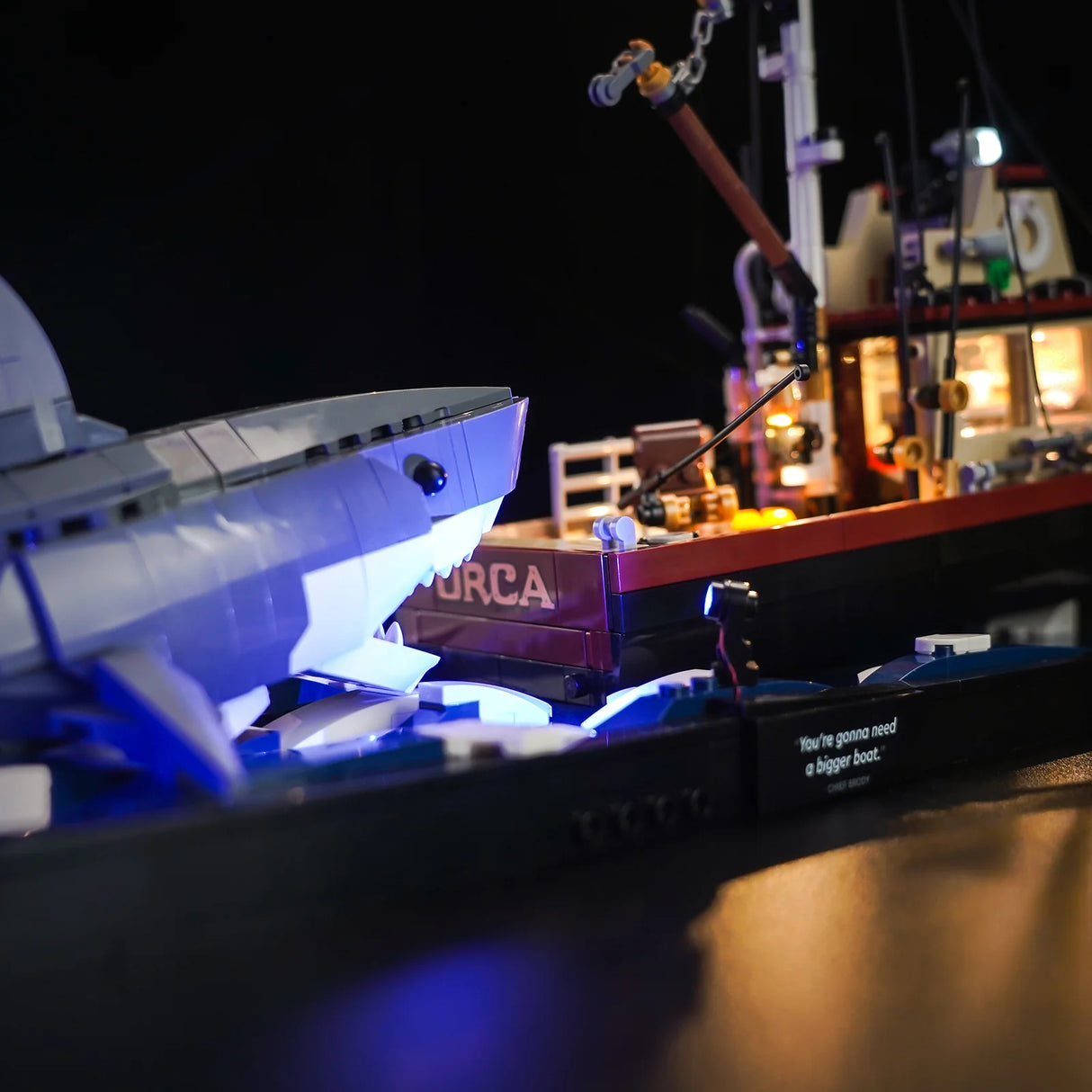Lego Modell des Bootes Orca mit einem Hai und einem Zitat auf einem schwarzen Sockel