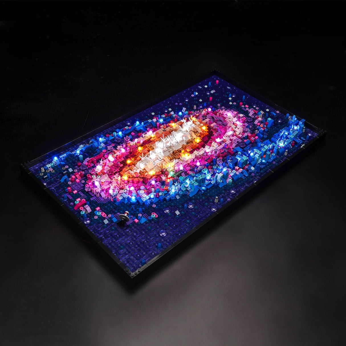 Beleuchtetes Lego Wandbild einer Galaxie mit bunten LED Lichtern auf schwarzem Hintergrund