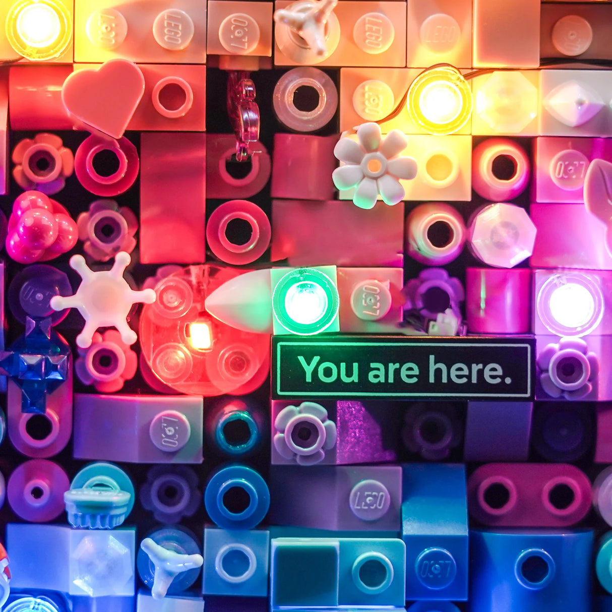 Bunte Lego Steine mit integrierten Lichtern und einem Schild mit der Aufschrift You are here