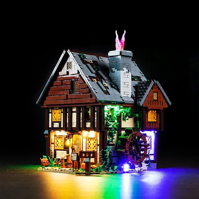 Beleuchtetes Lego Mittelalterhaus mit Wasserrad vor schwarzem Hintergrund