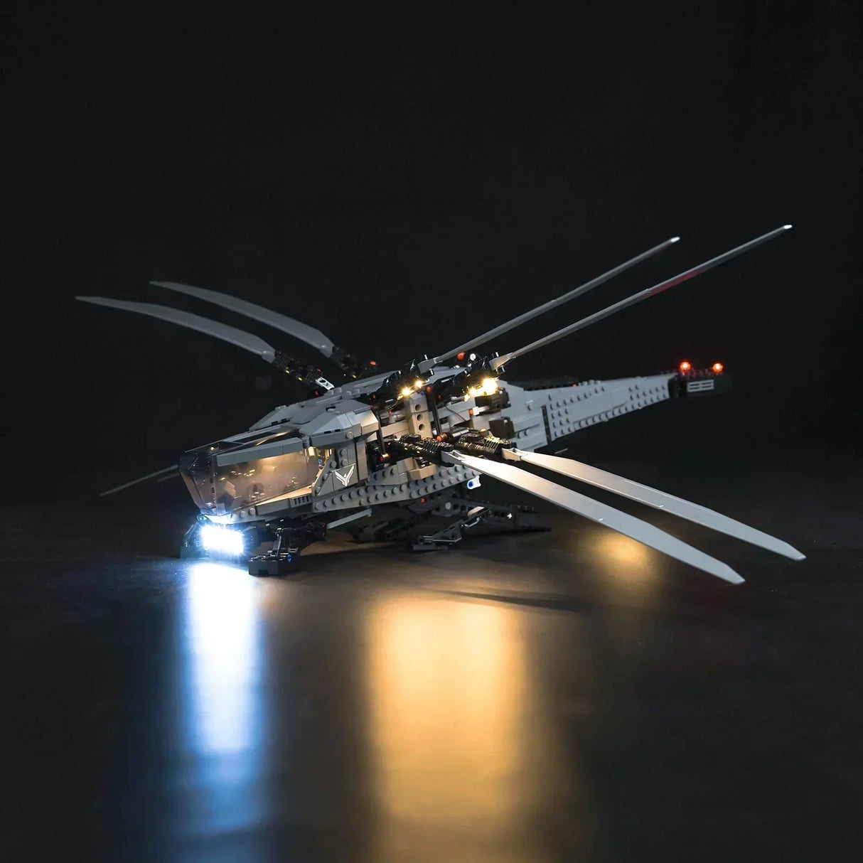 Beleuchtetes Lego Modell eines Ornithopters vor schwarzem Hintergrund