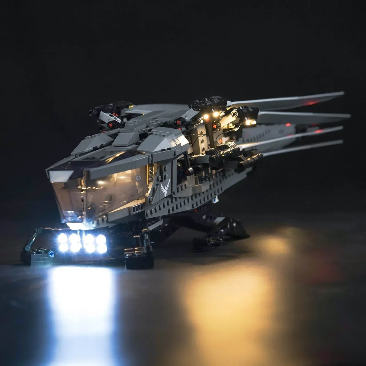 Beleuchtetes Lego Modell eines grauen Raumschiffs vor schwarzem Hintergrund