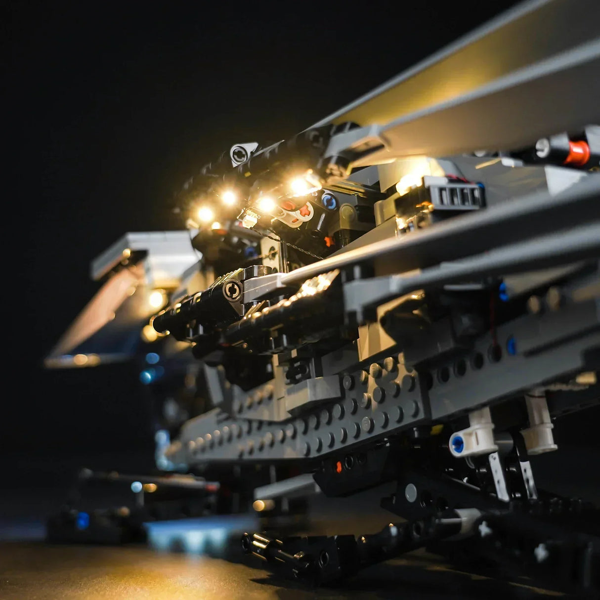 Detailansicht eines beleuchteten Lego Technic Modells vor schwarzem Hintergrund