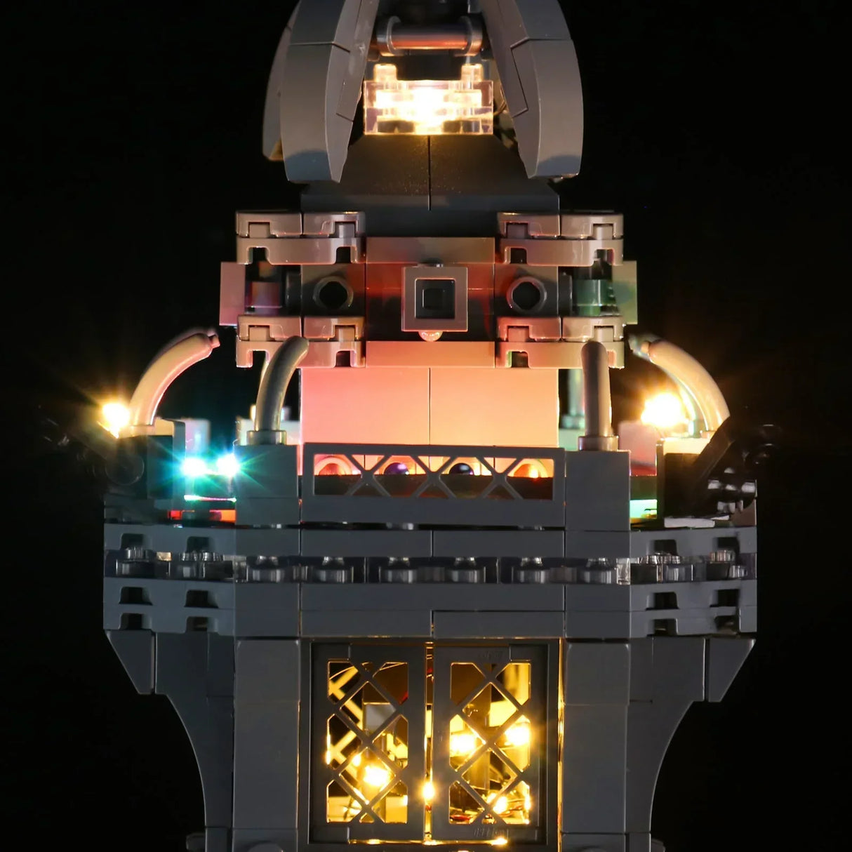 Symmetrische Nahaufnahme der oberen Etage des LEGO Eiffelturms mit farbwechselnder RGB-LED-Beleuchtung vor schwarzem Hintergrund. 44883432734948