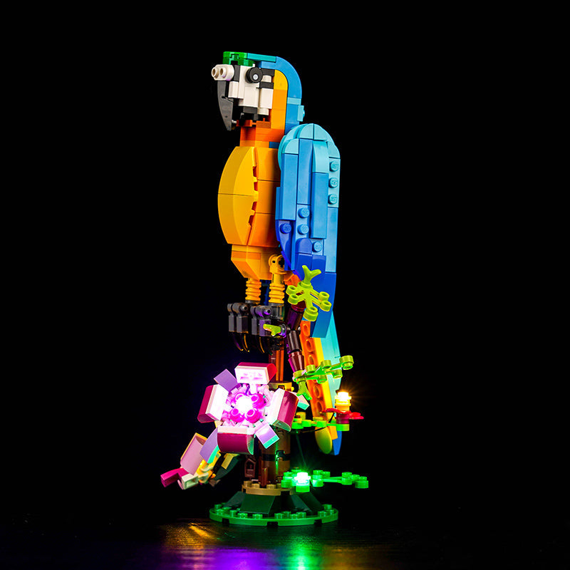 Lego Ara Papagei Modell mit LED Beleuchtung auf einem Ast vor schwarzem Hintergrund