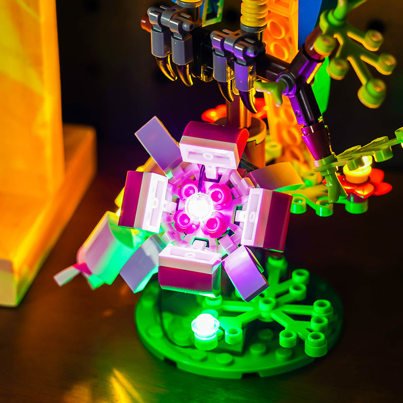 Beleuchtetes Lego Modell einer Blume mit violetten und weissen Bausteinen auf einem gruenen Sockel