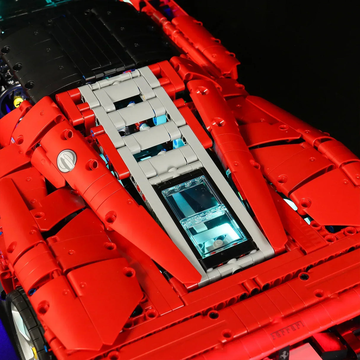 Draufsicht auf das Heck eines roten Lego Technic Ferrari Modells mit beleuchtetem Motorraum