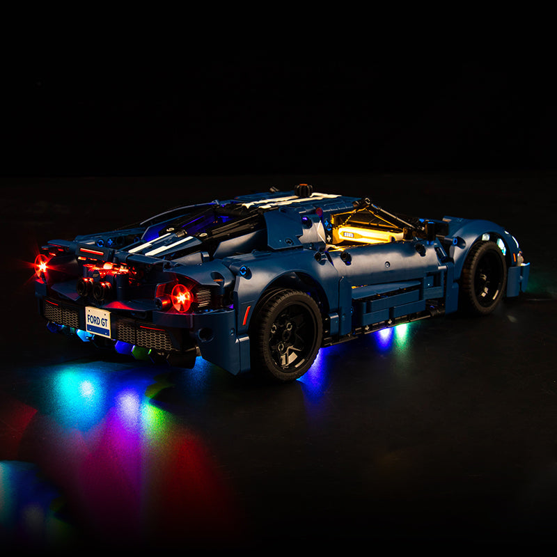 Blaues Ford GT Modellauto aus Klemmbausteinen mit leuchtender LED Beleuchtung vor schwarzem Hintergrund