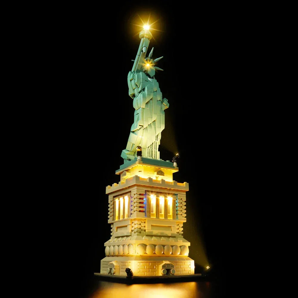 LEGO Architecture Freiheitsstatue (Set 21042) mit warmer LED-Beleuchtung komplett beleuchtet vor schwarzem Hintergrund in der Seitenansicht.