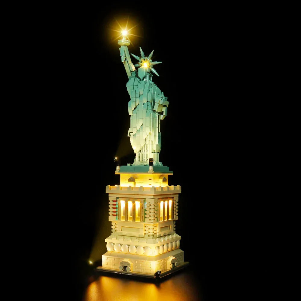 Frontalansicht der LEGO Architecture Freiheitsstatue mit aktivierter LED-Beleuchtung im Podest, in der Fackel und durch externe Bodenstrahler.