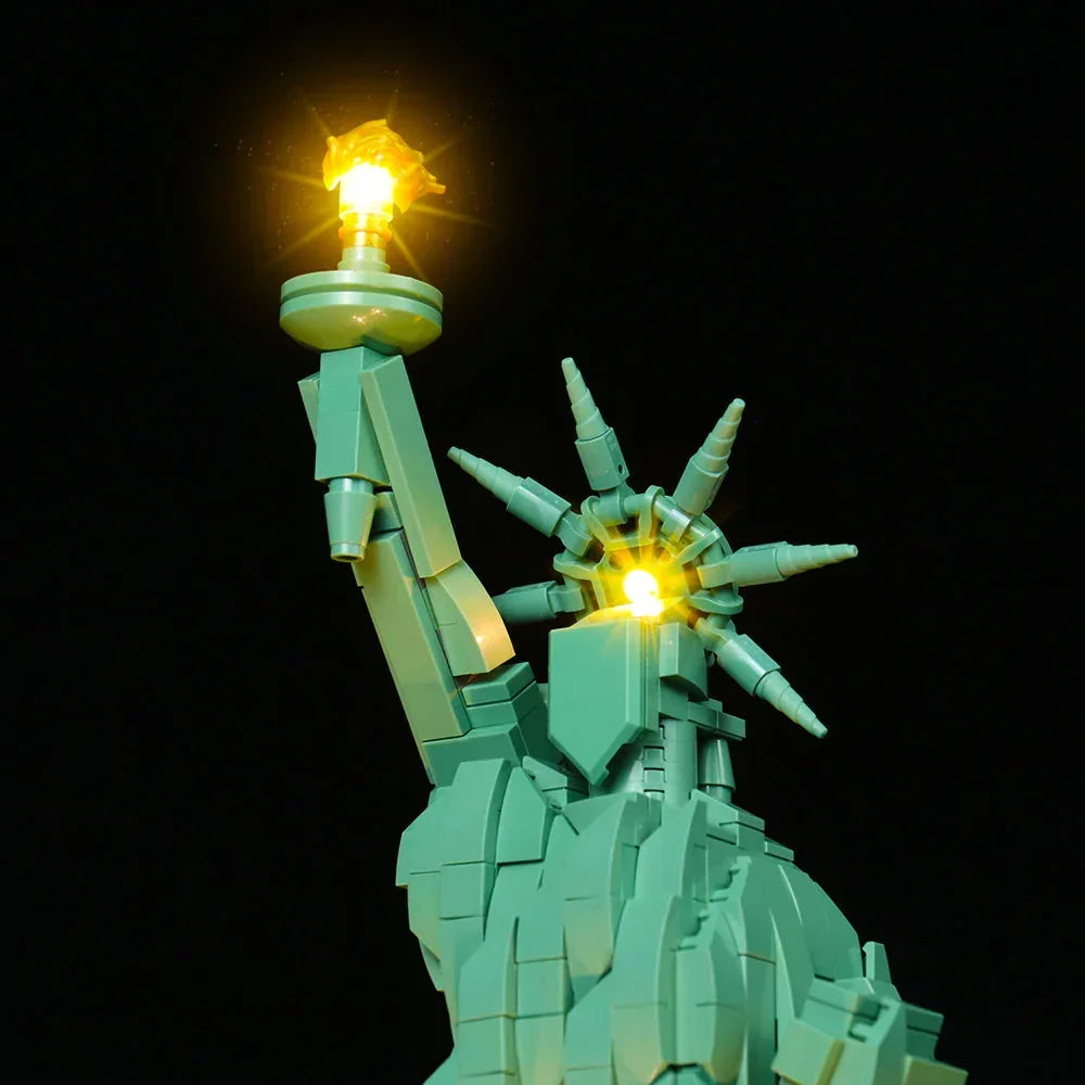 Nahaufnahme des Kopfes und der Fackel der LEGO Freiheitsstatue 21042 mit leuchtenden LED-Lichtern in der Krone und der Flamme.