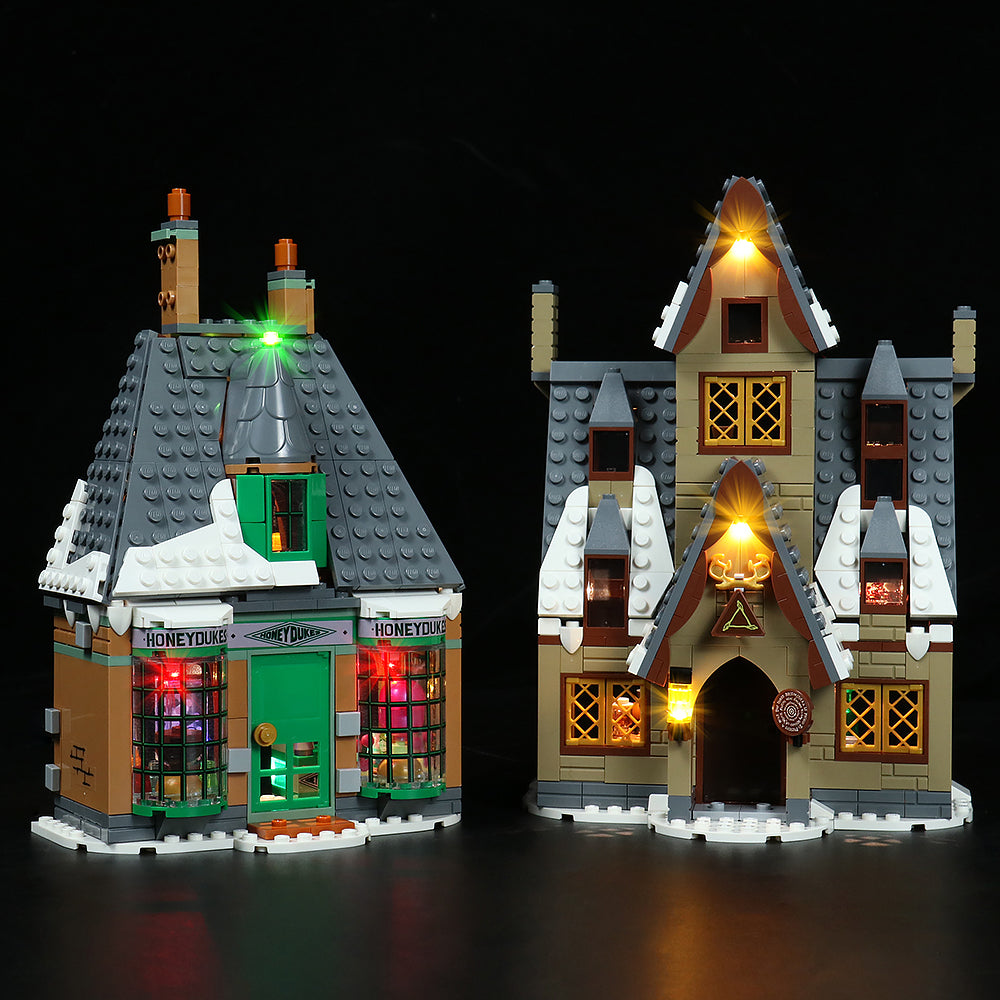 Beleuchtete Lego Harry Potter Gebaeude Honeydukes und Drei Besen vor schwarzem Hintergrund