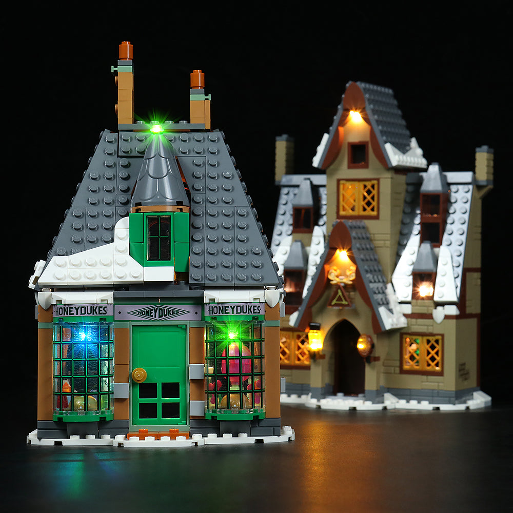 Beleuchtetes Lego Modell von Honigtopf und einem weiteren Gebäude vor schwarzem Hintergrund