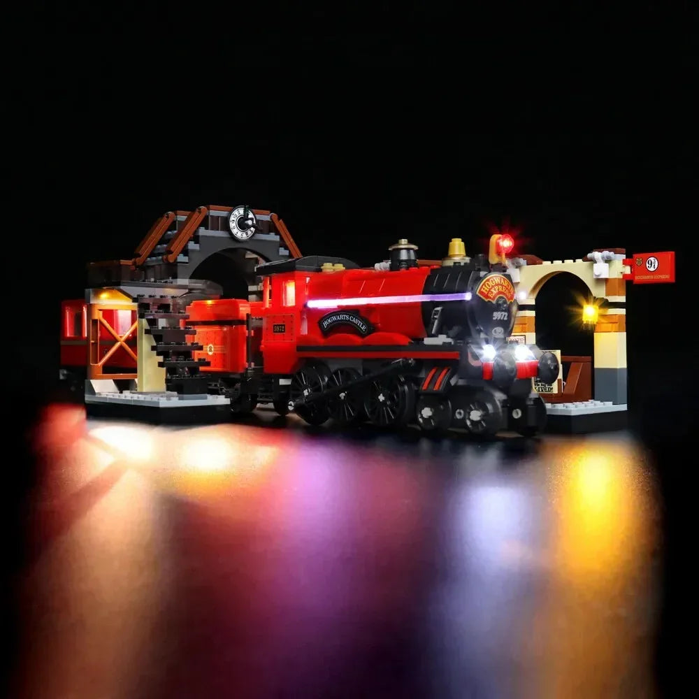 Beleuchtetes Lego Modell des Hogwarts Express mit Bahnhofsgleis neun dreiviertel vor schwarzem Hintergrund