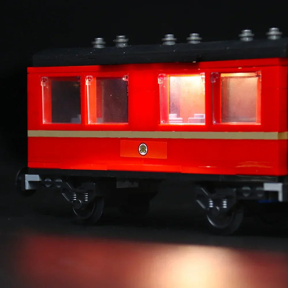 Roter Lego Eisenbahnwaggon mit beleuchteten Fenstern vor schwarzem Hintergrund
