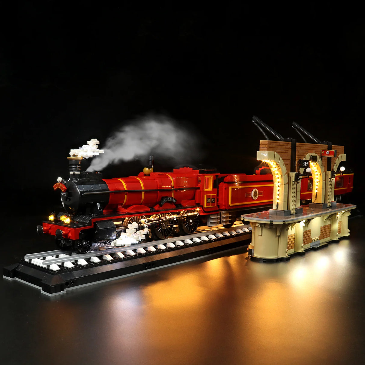 Beleuchtetes Lego Modell des Hogwarts Express Zuges mit Bahnsteig auf schwarzem Hintergrund