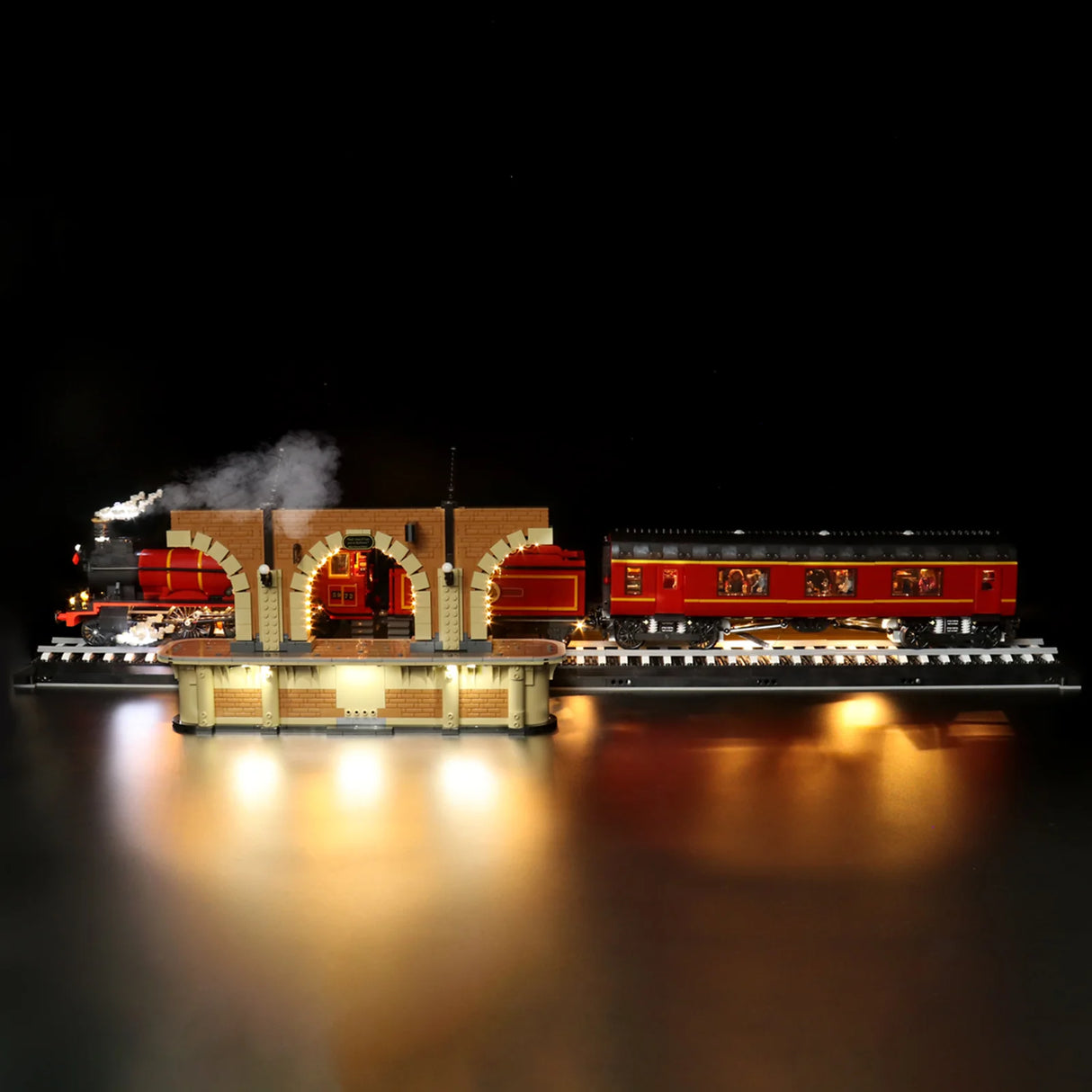 Beleuchtetes Lego Modell eines roten Dampfzuges an einem Bahnhof