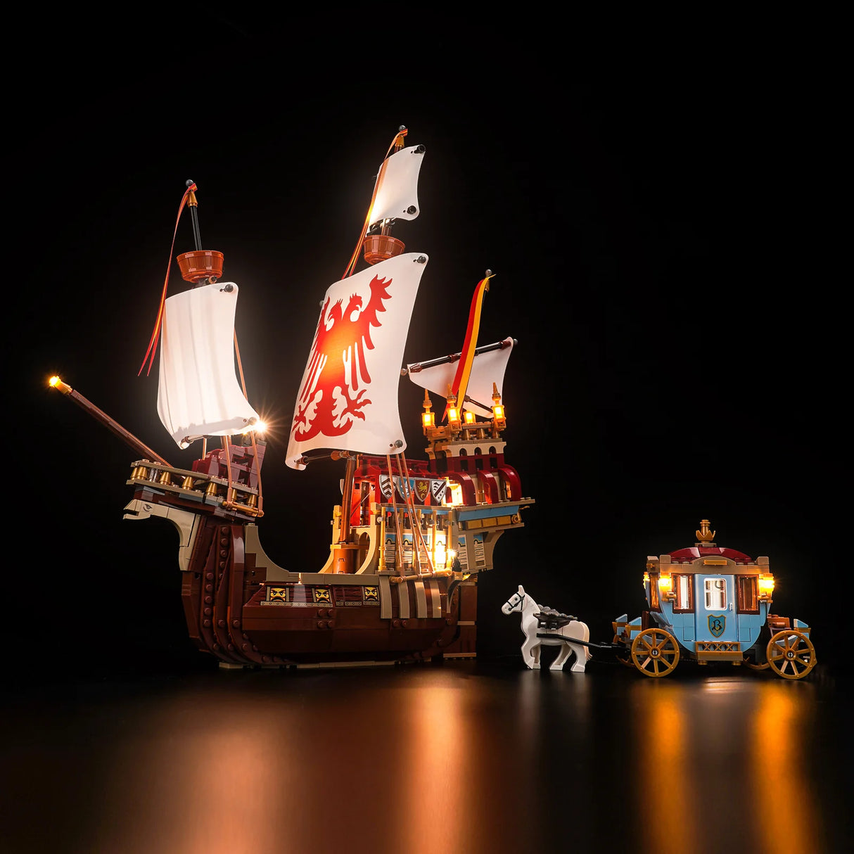 Beleuchtetes Lego Schiff mit Segeln und eine kleine Kutsche mit Pferd vor schwarzem Hintergrund