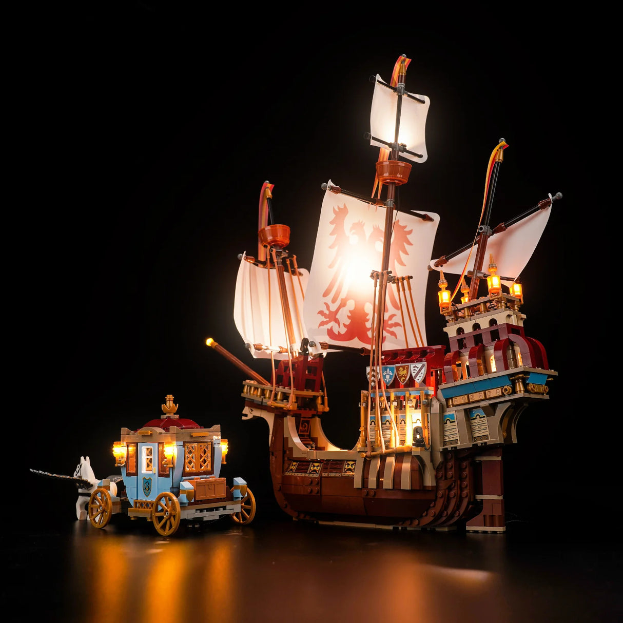 Beleuchtetes Lego Modell eines mittelalterlichen Schiffes und einer Kutsche vor schwarzem Hintergrund