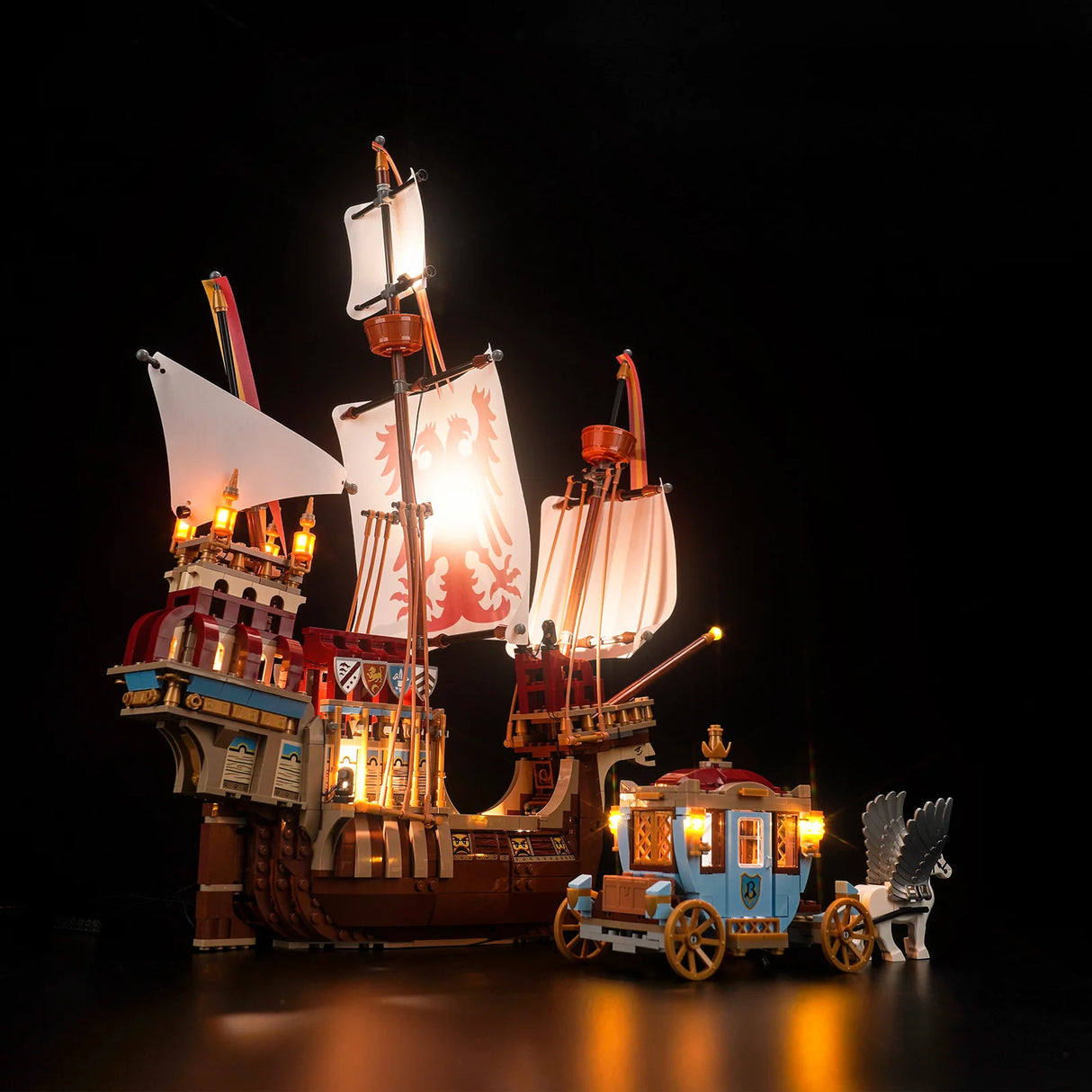 Beleuchtetes Lego Schiff und eine Kutsche mit geflügeltem Pferd vor schwarzem Hintergrund