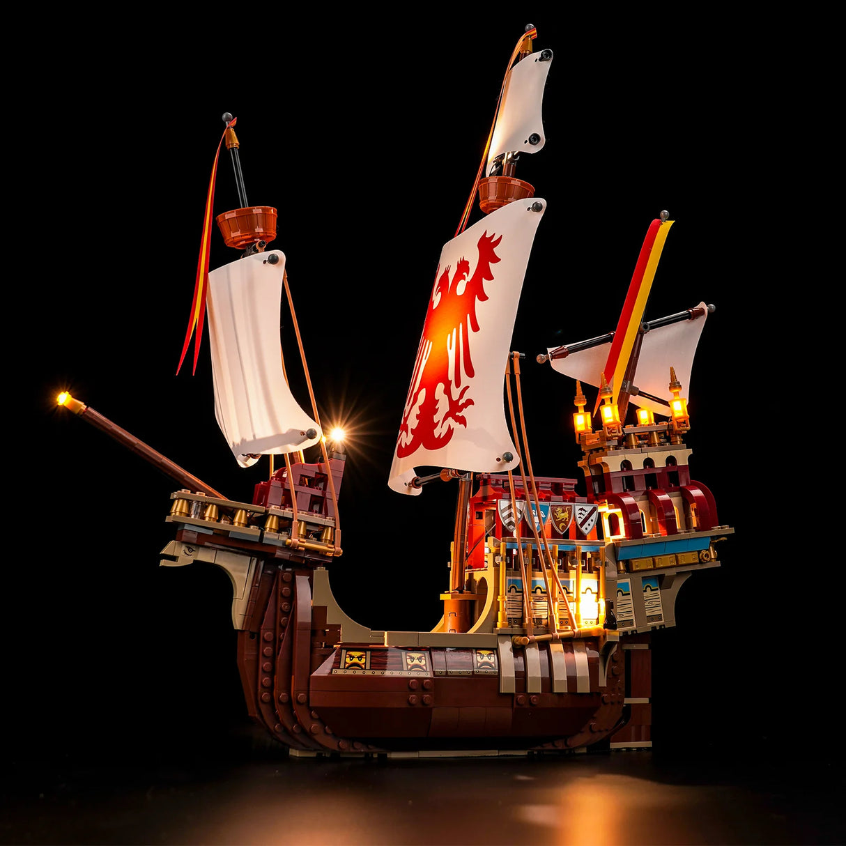 Beleuchtetes Lego Modell eines historischen Segelschiffs mit Wappen auf den Segeln vor schwarzem Hintergrund