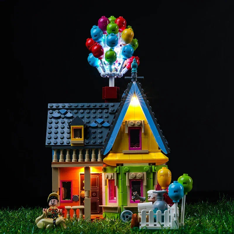 Beleuchtetes Lego Haus mit bunten Luftballons auf dem Dach