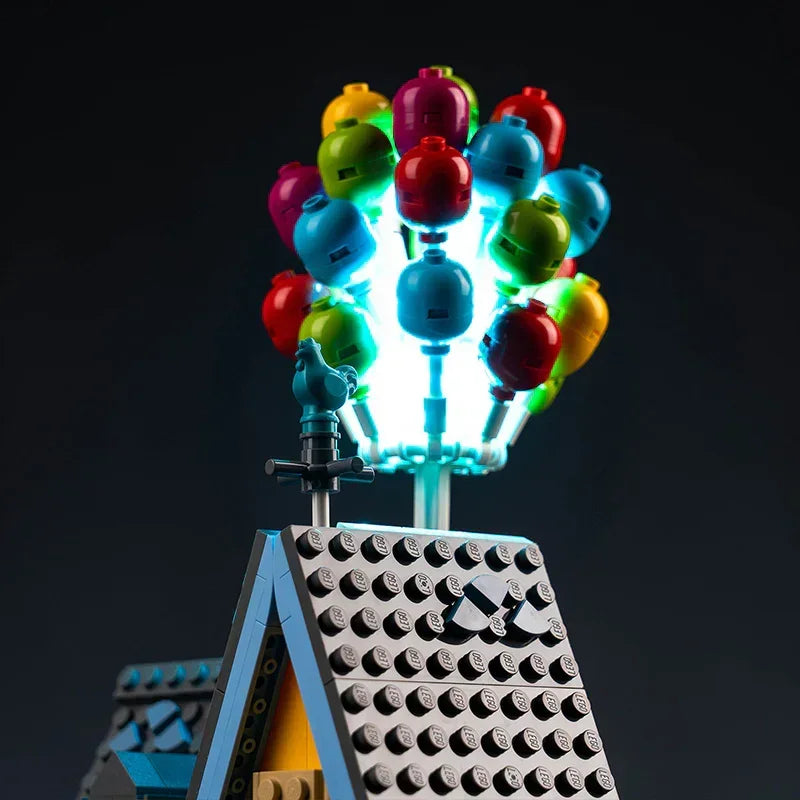 Buntes Lego Ballonbündel auf einem Hausdach mit Beleuchtung