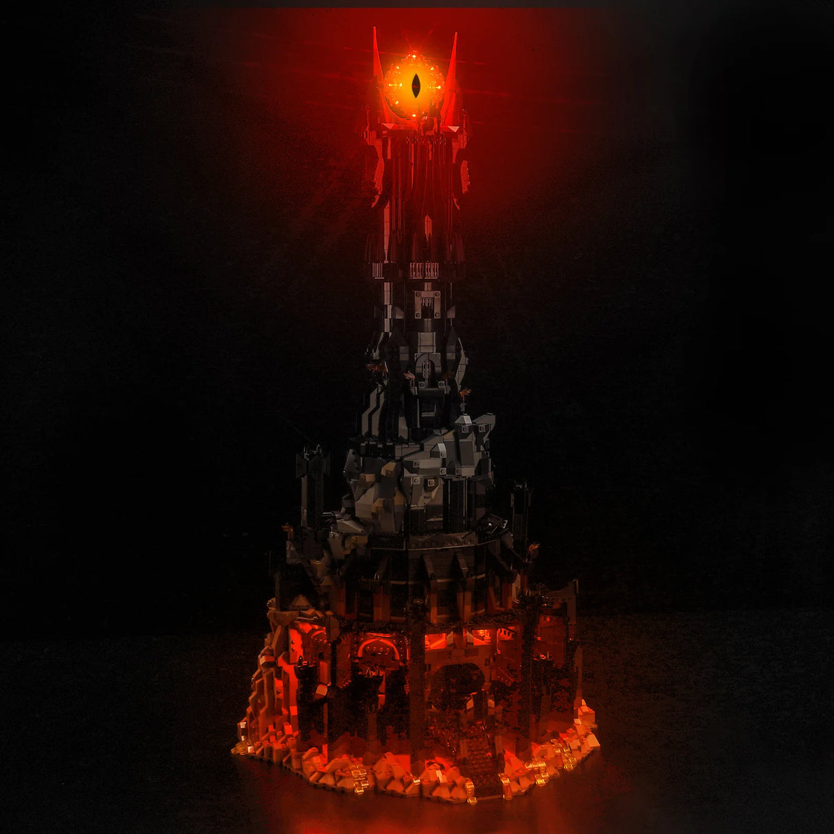 Lego Modell des Turms Barad-dur mit leuchtendem Auge von Sauron vor schwarzem Hintergrund