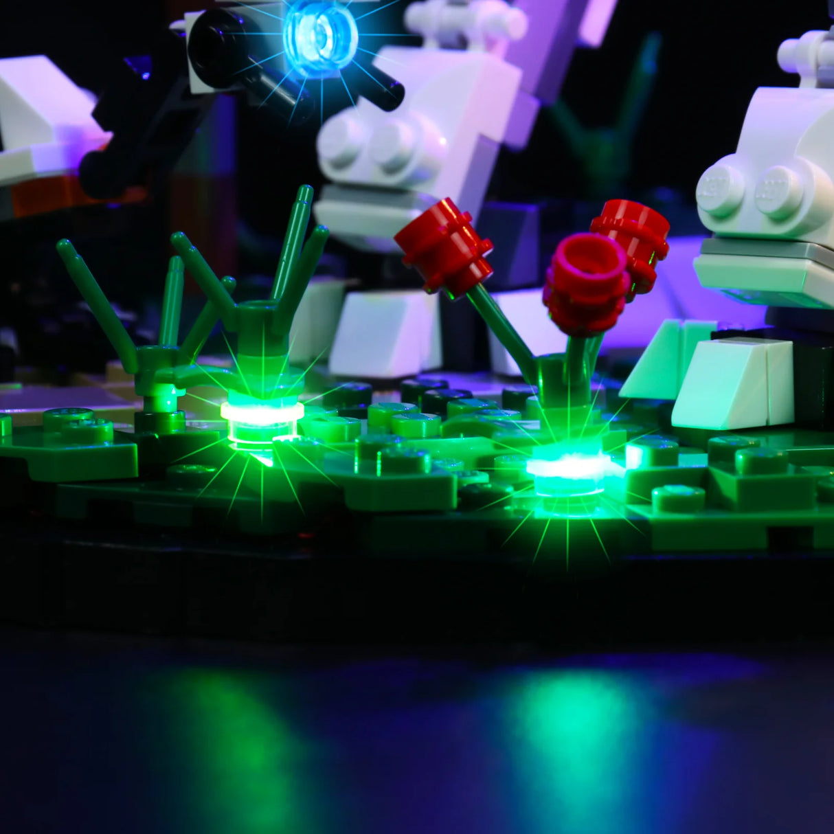 Beleuchtete Lego Pflanzen und Roboterfiguren im Dunkeln