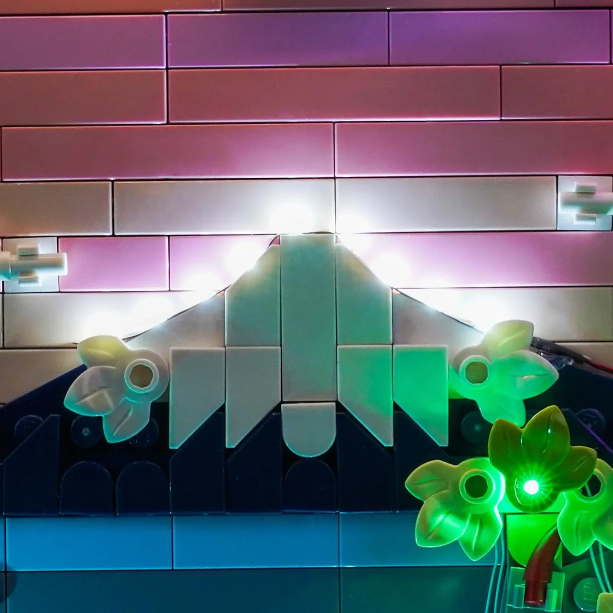 Beleuchteter Lego-Berg mit rosa Himmel und grünen Pflanzen