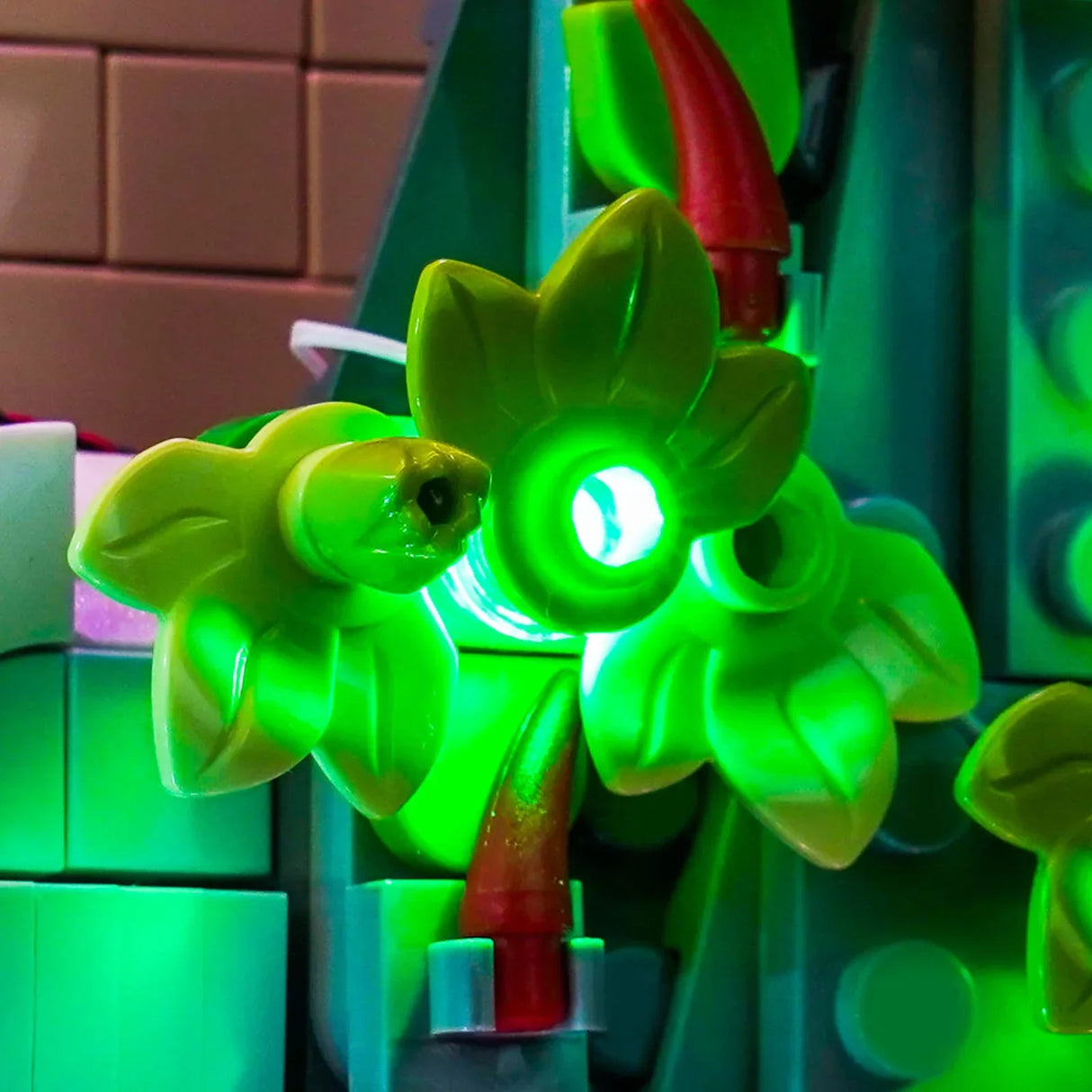 Nahaufnahme von leuchtend grünen Lego-Blättern mit einem roten Lego-Stück im Hintergrund