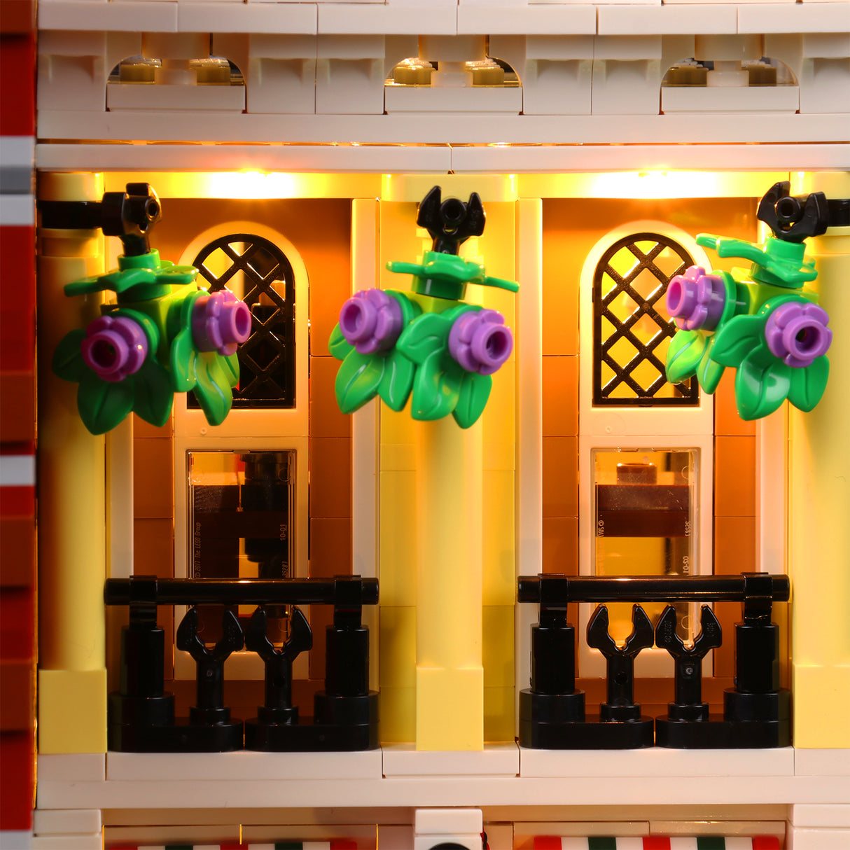 Beleuchtete Lego Fassade mit Balkonen und Blumenampeln
