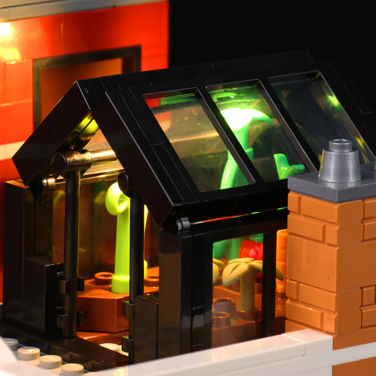 Beleuchtetes Lego Gewächshaus mit grünen Pflanzen und Backsteinschornstein