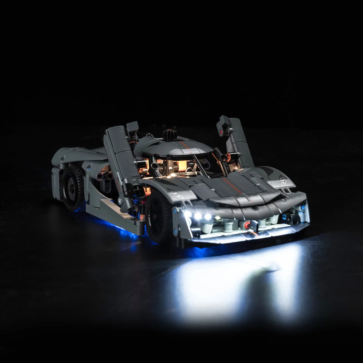 Graues Lego Technic Modell eines Sportwagens mit offener Flügeltür und eingeschalteter LED Beleuchtung