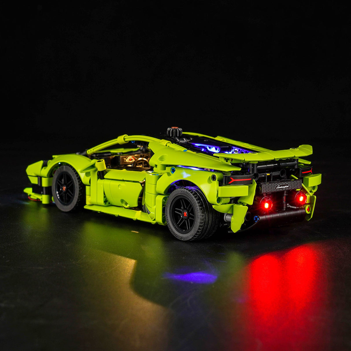 Gruenes Lamborghini Modellauto aus Klemmbausteinen mit leuchtenden Ruecklichtern vor schwarzem Hintergrund
