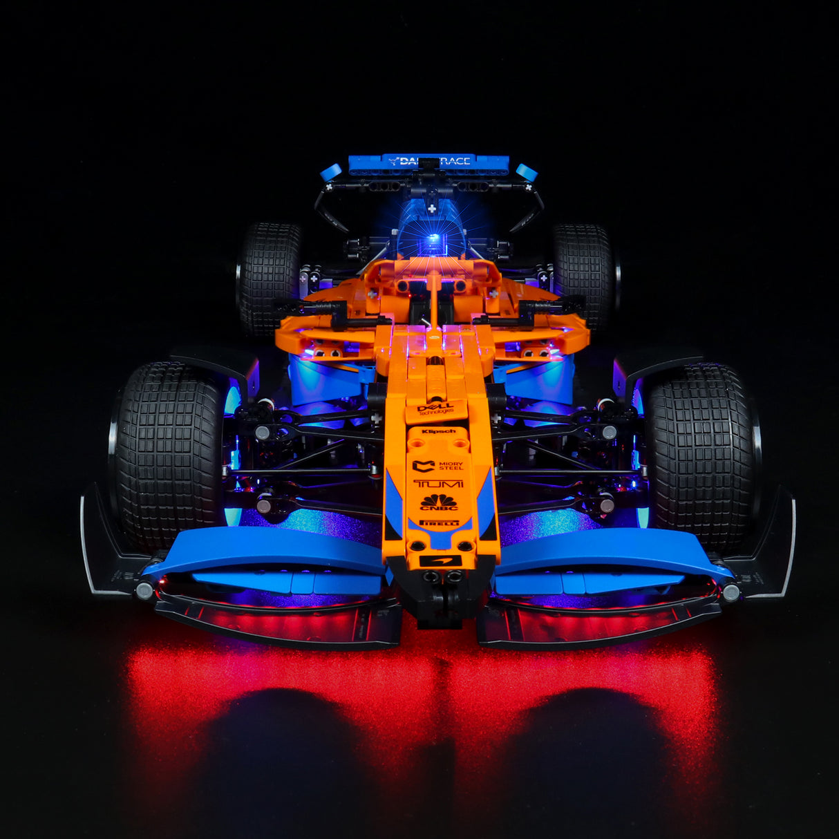 Orange und blaues Formel 1 Modellauto mit LED Beleuchtung auf schwarzem Hintergrund
