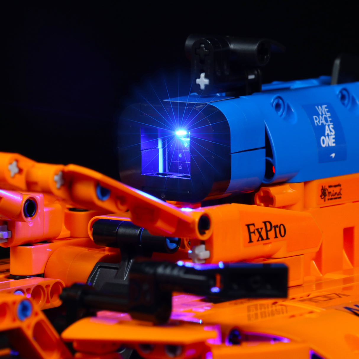 Detailansicht eines orangefarbenen Modellrennwagens mit blauer LED Beleuchtung