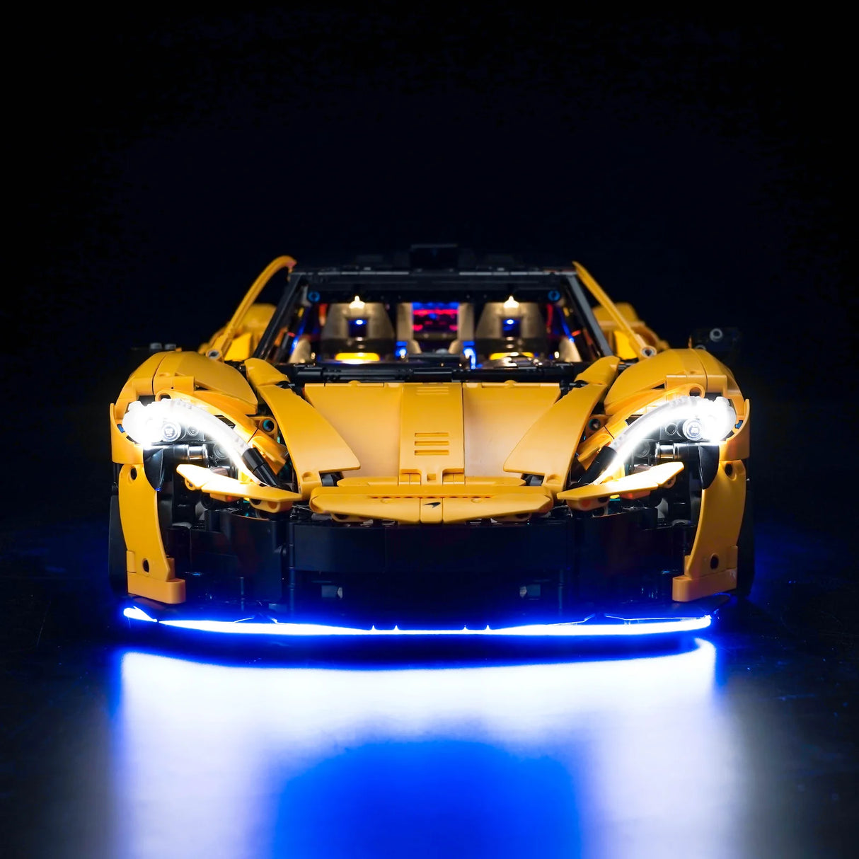 Gelbes Lego Technic McLaren Modellauto von vorne mit eingeschalteter LED Beleuchtung