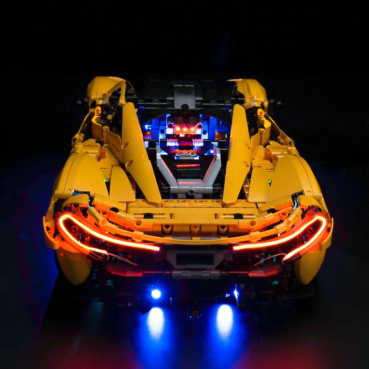 Gelbes Lego Technic McLaren P1 Modellauto von hinten mit leuchtenden roten Rücklichtern und blauer Unterbodenbeleuchtung