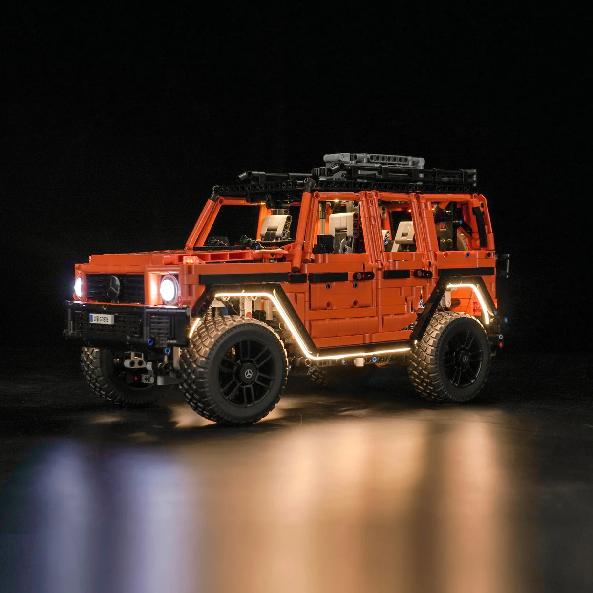 Beleuchtetes orangefarbenes Mercedes G-Klasse Modell aus Klemmbausteinen vor schwarzem Hintergrund